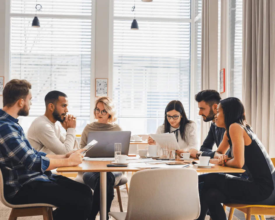 Fintech consultants and software engineers collaborating around a meeting table in a modern office