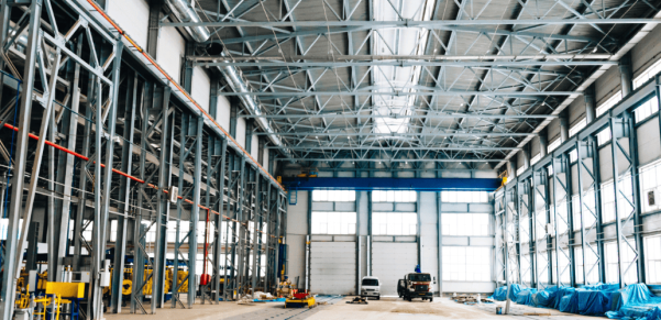 Interior of a large industrial steel manufacturing warehouse and re-rolling plant facility behind the header text for Shalimar Steel Re-rolling Mills.