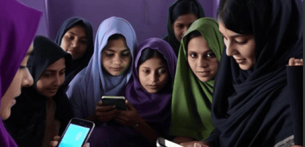 Group of women gathered inside a room using smartphones, representing CSC Pakistan's financial inclusion CRM initiative.